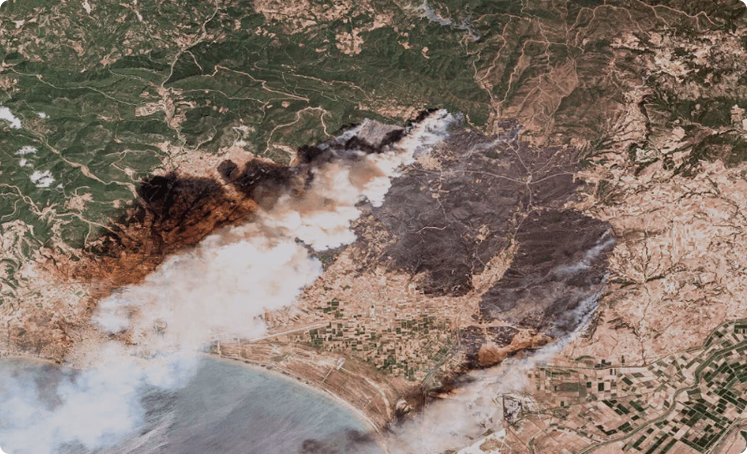 Satellite view of wildfire burning near a coastline