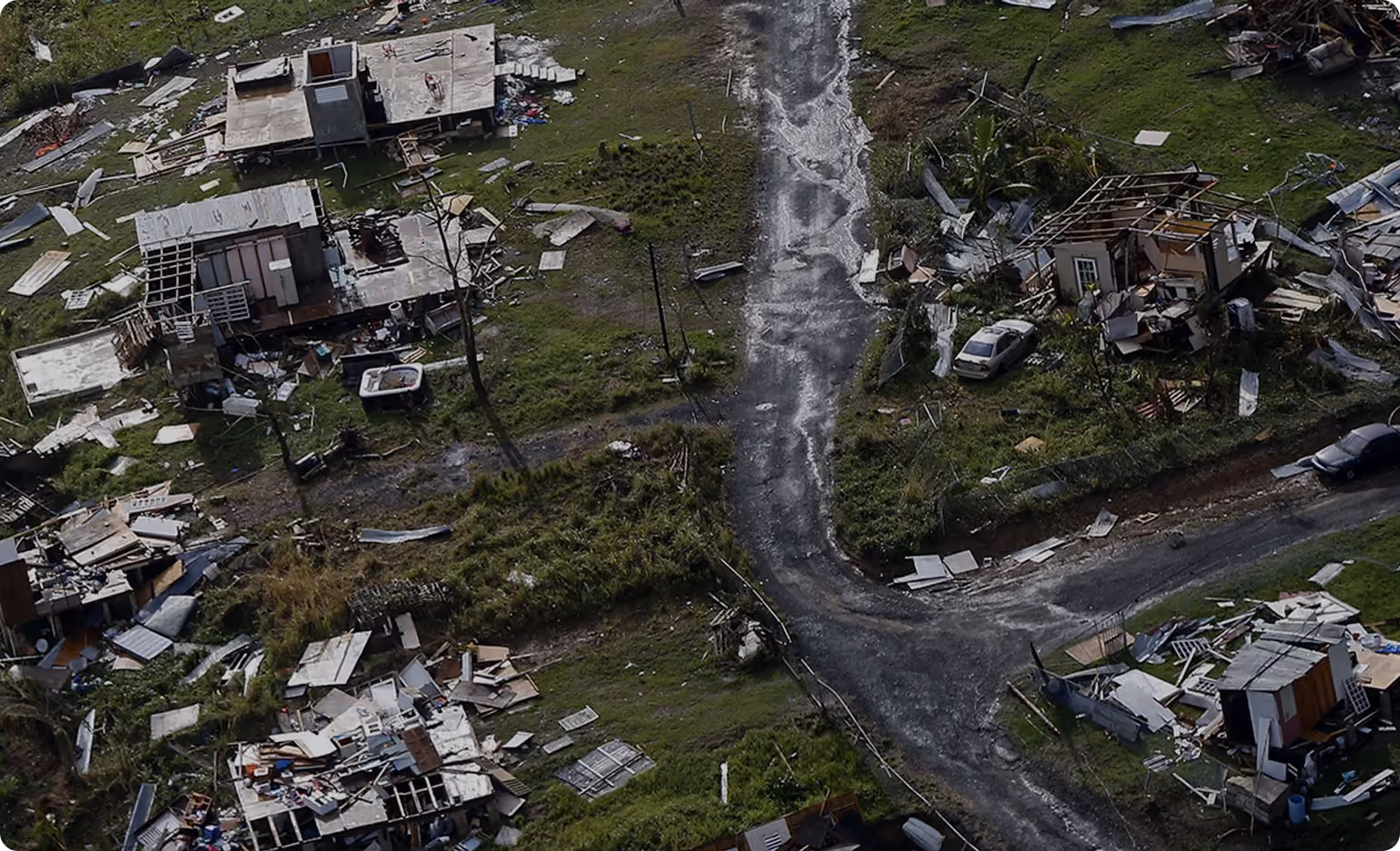 Aerial view of damaged homes around a curved road